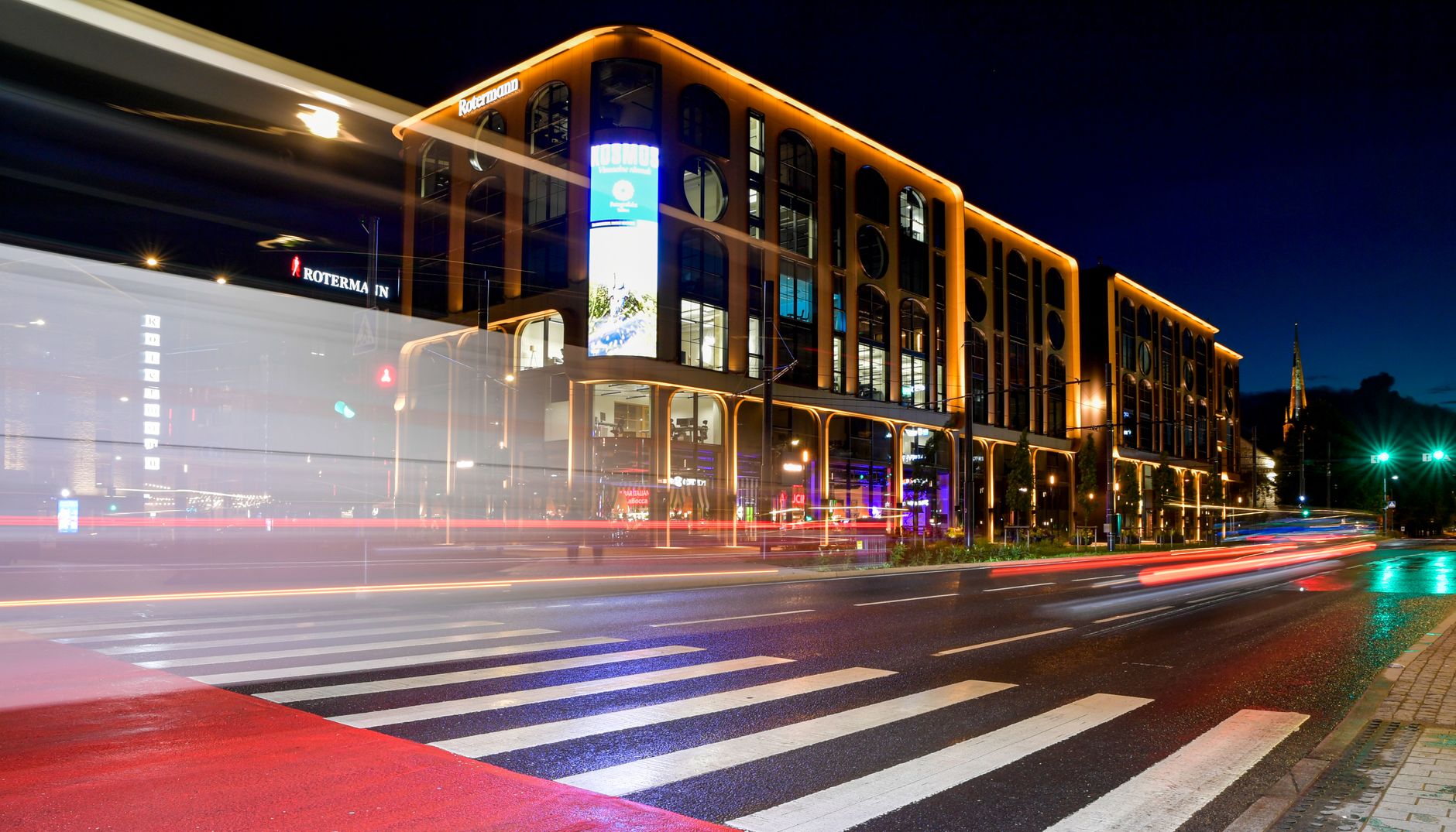 Vue réaliste d’un commerce dunkerquois équipé d’un caisson lumineux lisible en soirée, avec façade harmonieuse et rue passante en arrière-plan