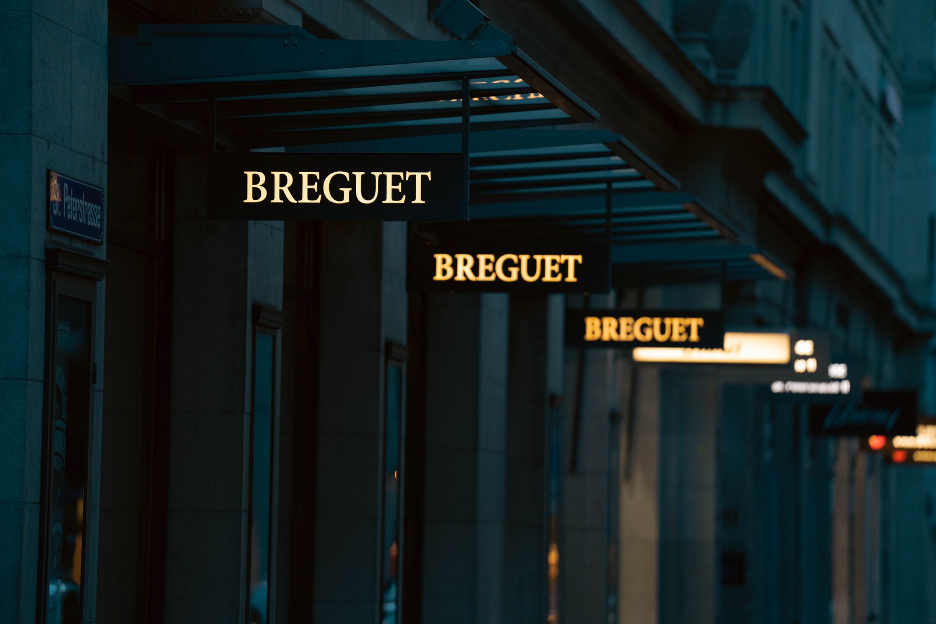 façade d’un commerce dunkerquois équipée d’une enseigne lumineuse élégante, visible en soirée, avec une rue commerçante en arrière-plan