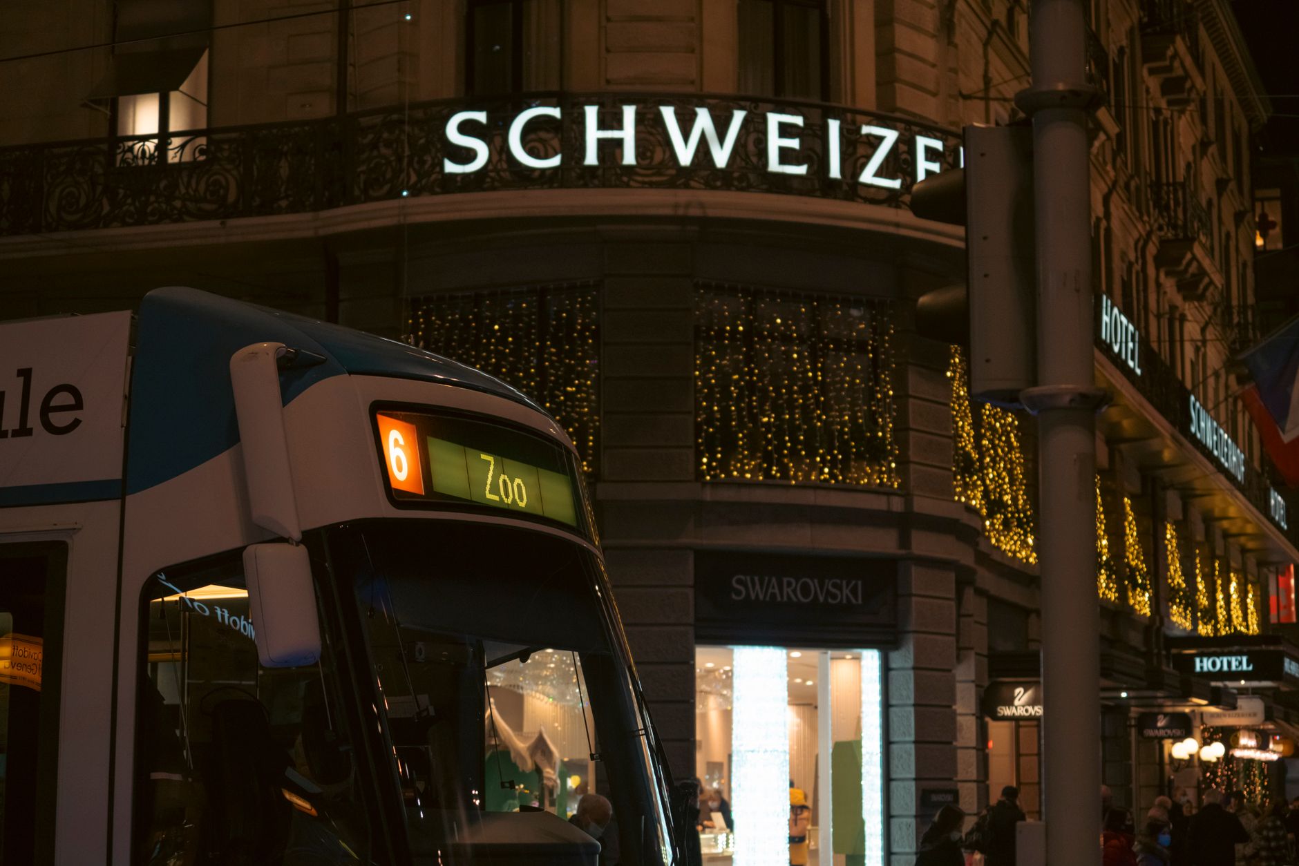 Façade d’une boutique dunkerquoise équipée d’une enseigne LED élégante, visible à la tombée de la nuit, avec un éclairage homogène et une rue commerçante en arrière-plan