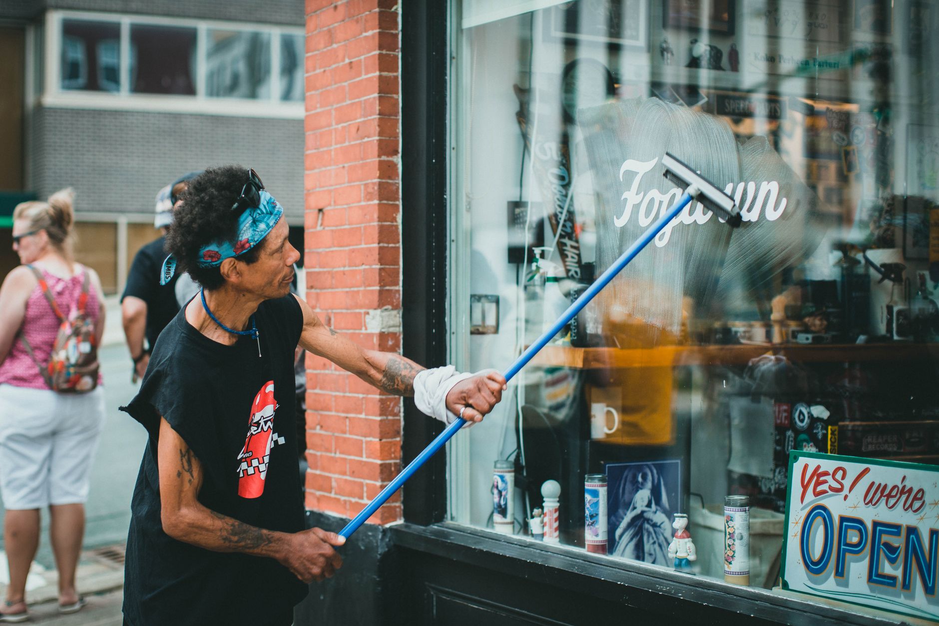 pose professionnelle d’un lettrage adhésif sur la vitrine d’une boutique, avec préparation et nettoyage précis du support