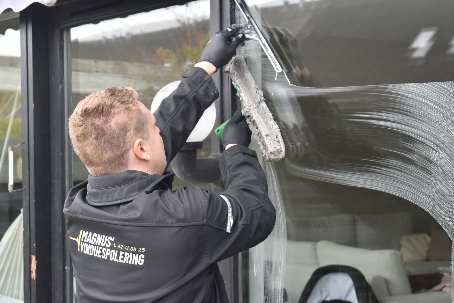 professionnel réalisant la pose d’une enseigne sur la façade d’une entreprise à Dunkerque, avec outils, nacelle et finitions soignées